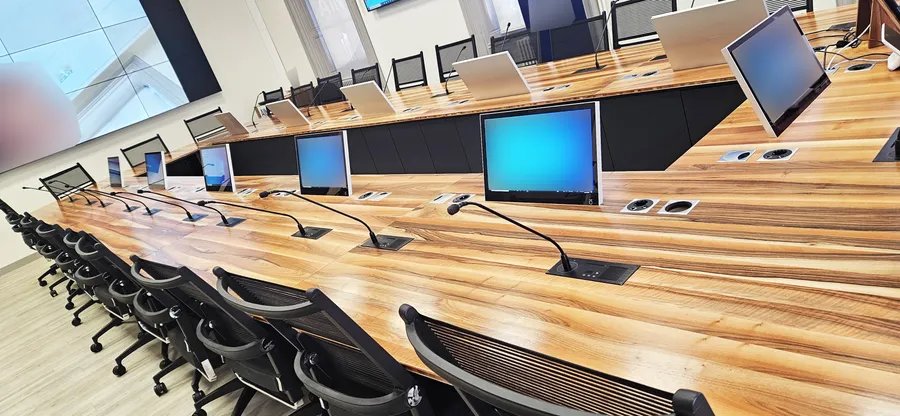 Écrans escamotables intégrés à une table de conférence